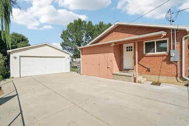 View of front of home featuring a garage, an outdoor structure, and brick siding
