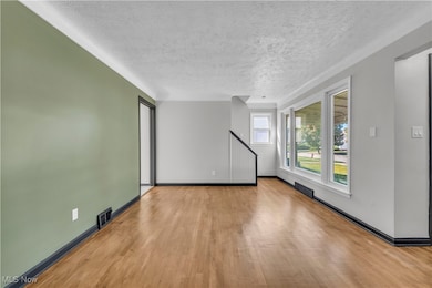 Unfurnished living room featuring wood finished floors and a textured ceiling