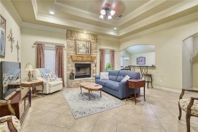 Living area with a tray ceiling, ceiling fan, orna