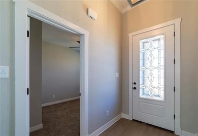 Foyer entrance with baseboards and crown molding
