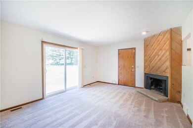 Living room with a wood-burning fireplace and sliders to the backyard.