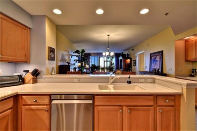 Open kitchen with breakfast bar and matching wet bar shown to the right.
