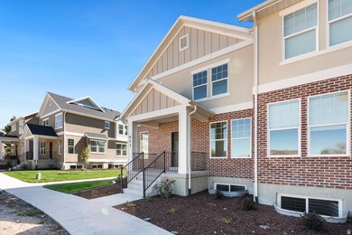 View of front facade with brick siding, board and batten siding, and a front yard