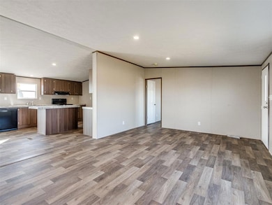 Unfurnished living room with light wood-style floors, ornamental molding, and recessed lighting