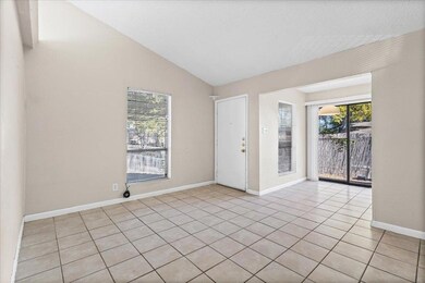 Spare room featuring vaulted ceiling and light tile patterned floors