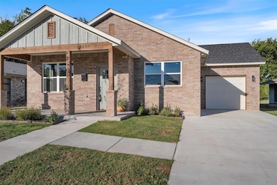View of front facade featuring a front yard, a porch, and brick siding