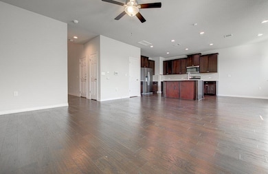 Unfurnished living room with a ceiling fan, baseb