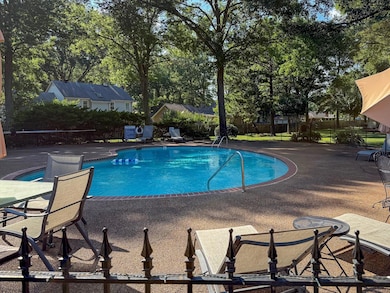 Community pool featuring a patio area and view of scattered trees