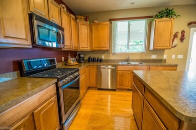 The kitchen offers stainless steel appliances, a center island and maple cabinets.