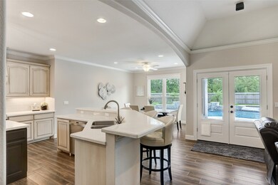 To the left of the living room is the spacious, light-filled kitchen space with quartz countertops. The designer selected tile flooring that emulates wide plank wood floors but offers the durability many yearn for. The French doors to the right of the breakfast room provide access to the covered patio.