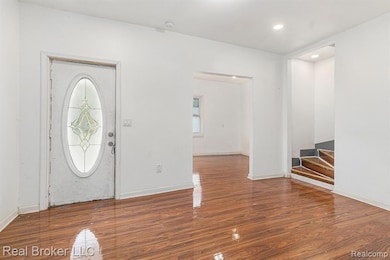 Entryway with dark wood-type flooring, recessed lighting, and stairs
