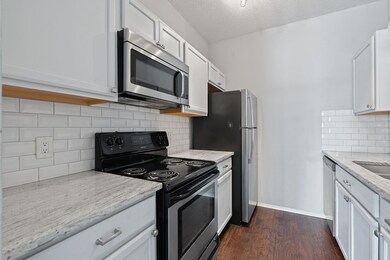 Kitchen featuring light stone countertops, a text