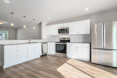 The great room flows into the kitchen, separated by a breakfast bar that can accommodate bar stools with pendant lighting above. The kitchen has quartz counters accented by subway tile backsplash and access to 10x10 patio & rear yard. Appliances Incl
