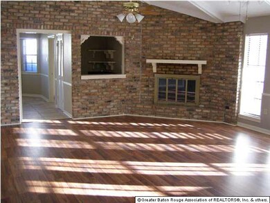 Living room has rich wood laminate floors, firepla