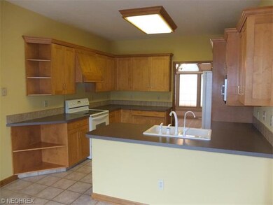 Fully applianced kitchen with tile floor.