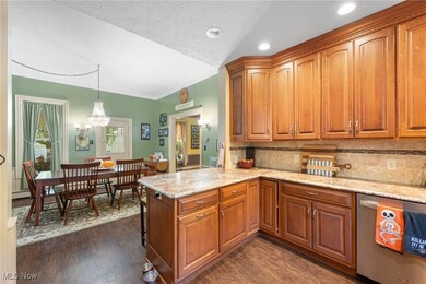 Kitchen with pendant lighting, a textured ceiling, dishwasher, crown molding, and dark hardwood / wood-style flooring