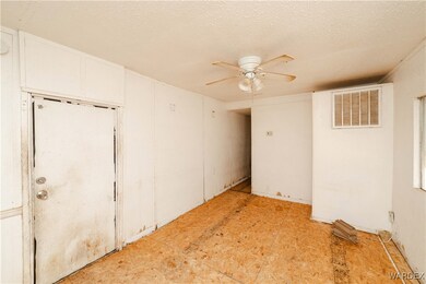 Empty room featuring a textured ceiling, visible v