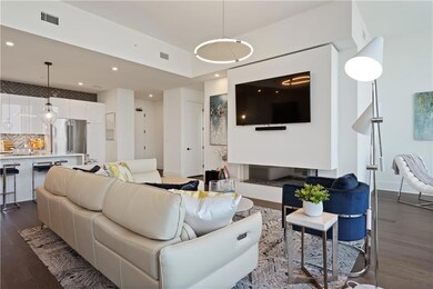 Living area with expansive windows, wood finished floors, a chandelier, and a water view