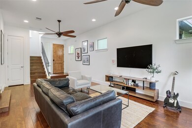 Living room with ceiling fan, stairs, hardwood / 