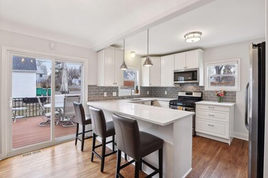 Impressive kitchen features a peninsula with seating and sliding glass door