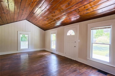 Entryway featuring dark wood-type flooring, wooden walls, lofted ceiling, and wooden ceiling