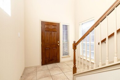 Foyer with light tile patterned flooring and stairs