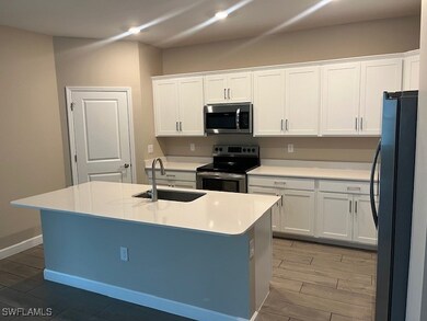 Kitchen featuring white cabinetry, sink, stainless
