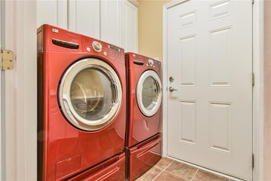 Laundry area with cabinet space, tile patterned fl