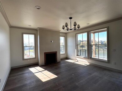 Unfurnished living room with dark wood-type flooring, a chandelier, ornamental molding, and a tiled fireplace