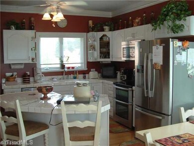 Kitchen. WOW, what a kitchen! Enjoy preparing dinner in the double oven and using the efficient Whirlpool gold series stainless appliances. If you love while cabinets, white ceramic tile counters, a large bar for snacking, crown moldings & accent lighting