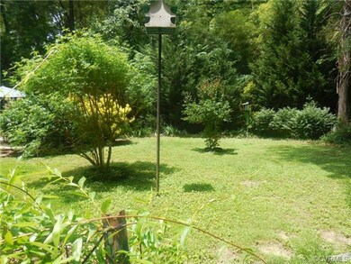 The park-like back yard is fringed by trees, allow