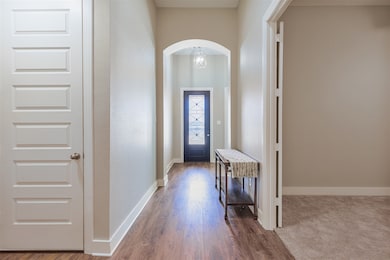 Doorway featuring arched walkways and wood finished floors