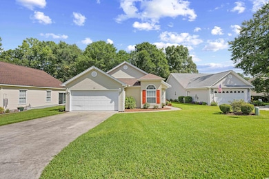 Ranch-style home with concrete driveway, an attached garage, and a front lawn