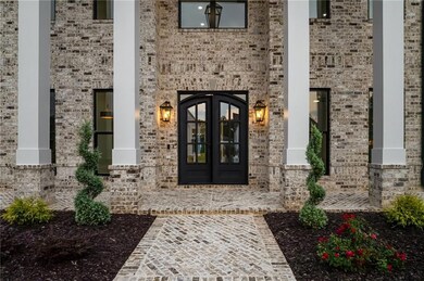 View of exterior entry featuring brick siding and french doors