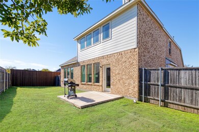 Rear view of house with a yard and a patio