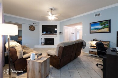 Living room with a brick fireplace, light tile pat