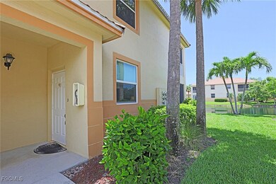 Doorway to property featuring stucco siding, a lawn, and a water view
