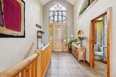 Foyer with light tile patterned floors and high va