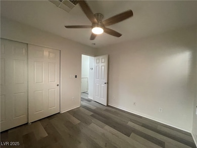 Unfurnished bedroom with dark wood-type flooring, a ceiling fan, and a closet