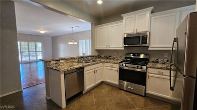 Kitchen featuring a sink, a peninsula, stainless s