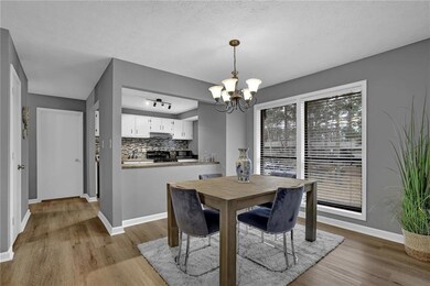 Dining space with a chandelier, wood finished floors, and a textured ceiling