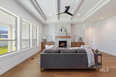 Living area with ceiling fan, a fireplace, wood finished floors, beamed ceiling, and recessed lighting