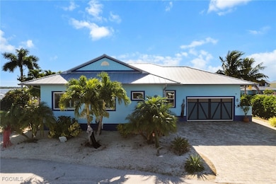 Single story home with a metal roof, stucco siding, an attached garage, and driveway