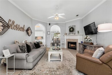 Living area featuring crown molding, arched walkwa