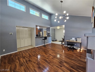Office with baseboards, a towering ceiling, wood f