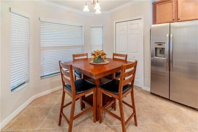 Dining space featuring an inviting chandelier, ornamental molding, and light tile patterned flooring