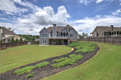 Rear view of house with a fenced backyard, a chimney, a wooden deck, and a patio area