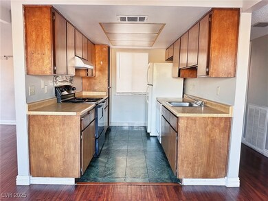 Kitchen featuring black stove, a sink, baseboards,
