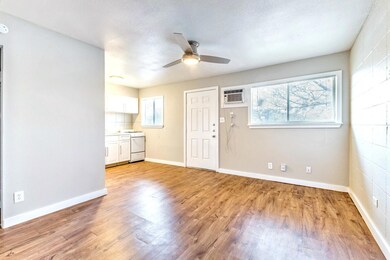 Empty room featuring an AC wall unit, a ceiling f