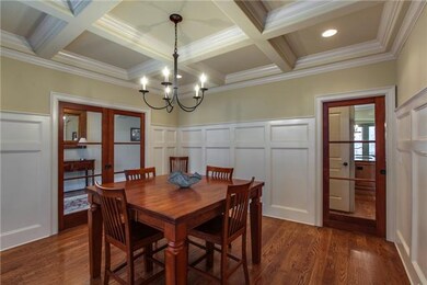 Formal dining room with coffered ceiling, pocket doors with glass, and recessed lights.